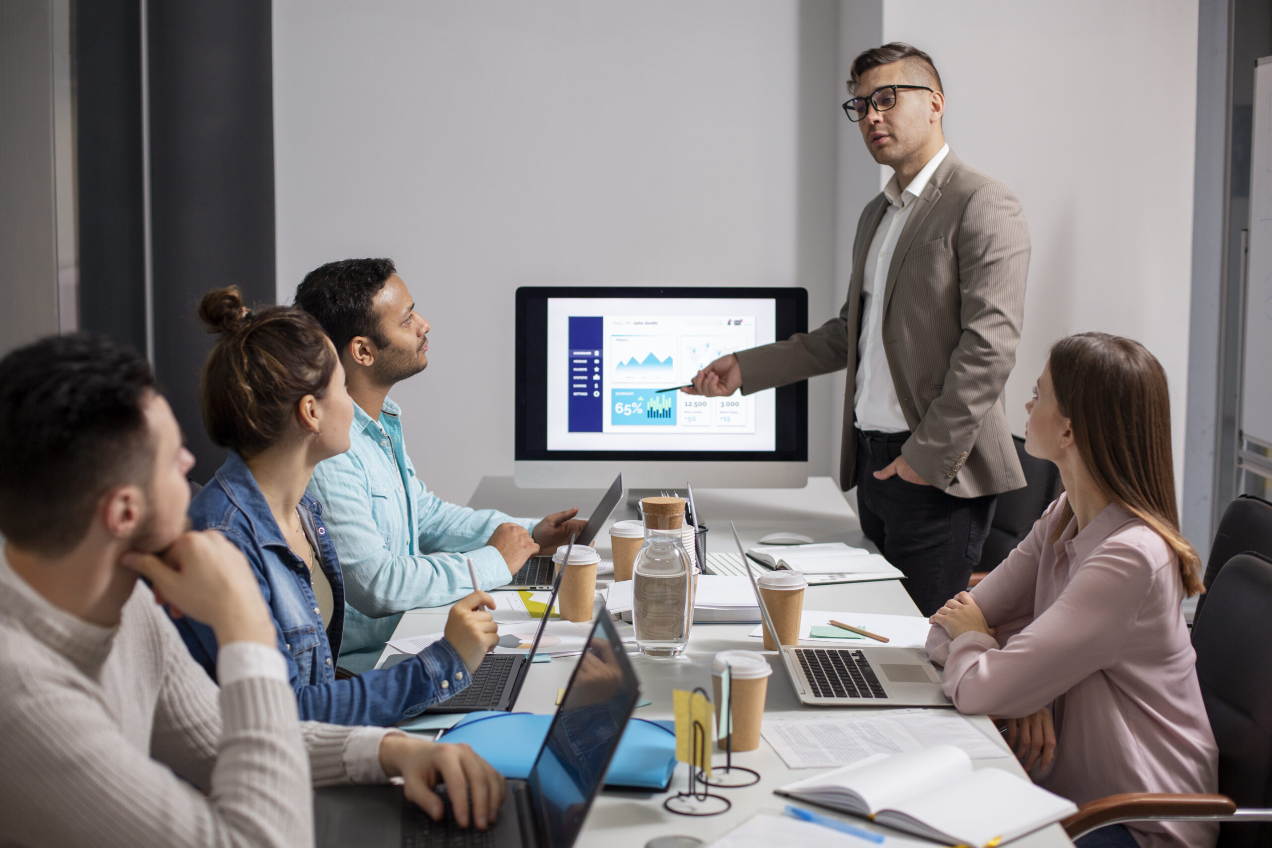A professional team discussing strategy in front of a large screen - Stevens Law Group